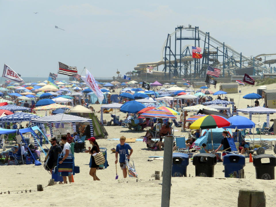 Beachgoers fill the sand in North Wildwood, N.J., Friday, July 7, 2023, the day after New Jersey environmental authorities warned the city to stop doing unauthorized repairs to its protective sand dunes. The state has already fined the city $12 million for the unauthorized work, which it says is weakening the dunes. (AP Photo/Wayne Parry)