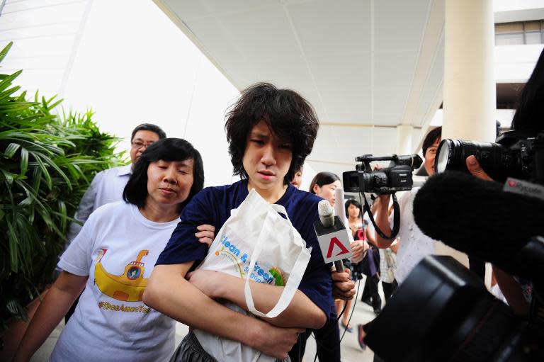 Singapore teenage blogger Amos Yee (C), accompanied by his mother Mary Toh Ai Buay (2nd L) and father Alphonsus Yee (back L), walks free from the state court in Singapore on July 6, 2015