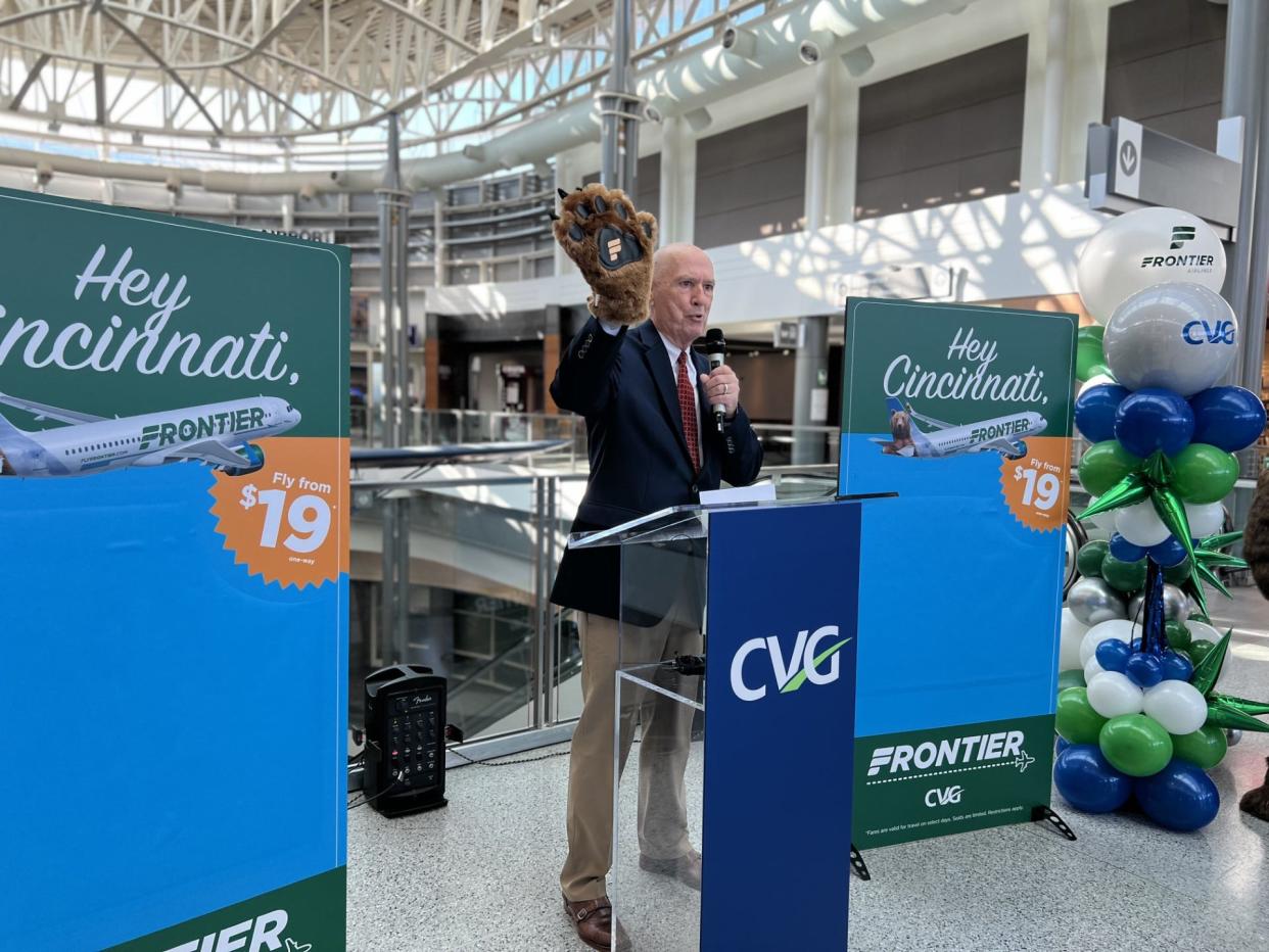 Frontier Airline Senior Director Michael Pewther announces expanded service from Cincinnati/Northern Kentucky International Airport with a paw from Griz the Bear, a company spokesman.