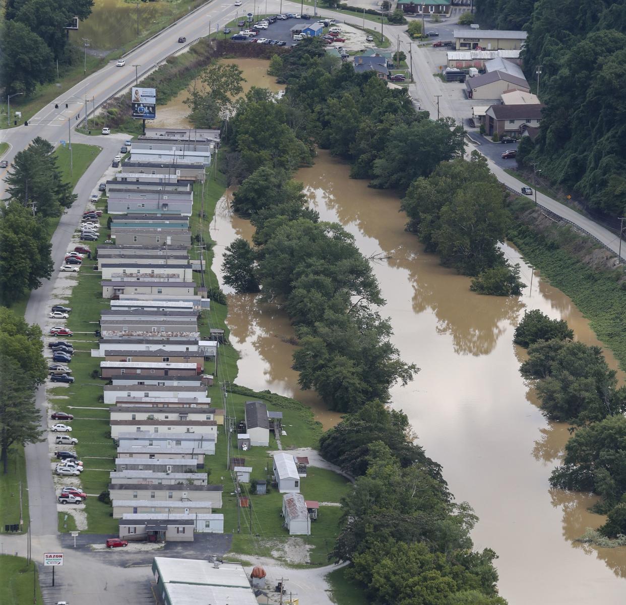 The river is still high around the homes in Breathitt County, Ky., on Saturday, July 30, 2022. Recovery has begun in many of the narrow hollers after historic rains flooded many areas of Eastern Kentucky killing more than two dozen people. A layer of mud from the retreating waters covers many cars and homes.