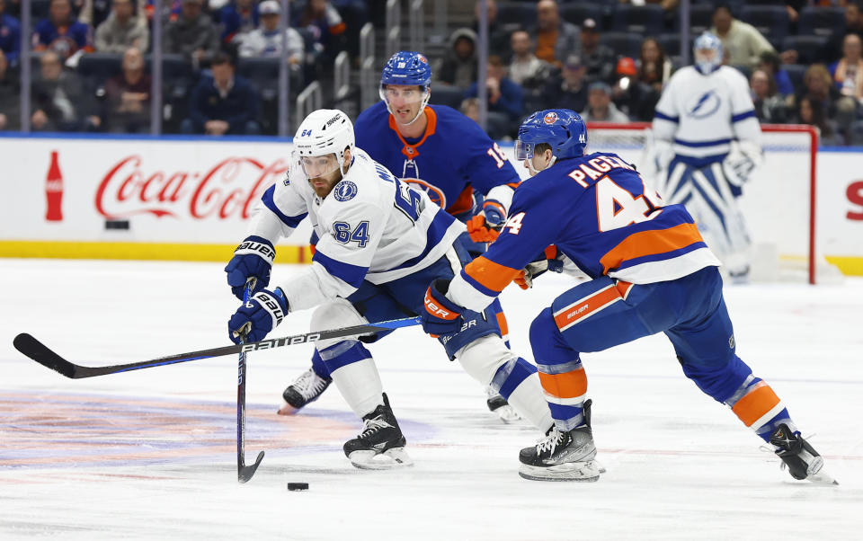 Tampa Bay Lightning center Tyler Motte (64) plays the puck against New York Islanders center Jean-Gabriel Pageau (44) during the first period of an NHL hockey game, Thursday, Feb. 8, 2024, in New York. (AP Photo/Noah K. Murray)