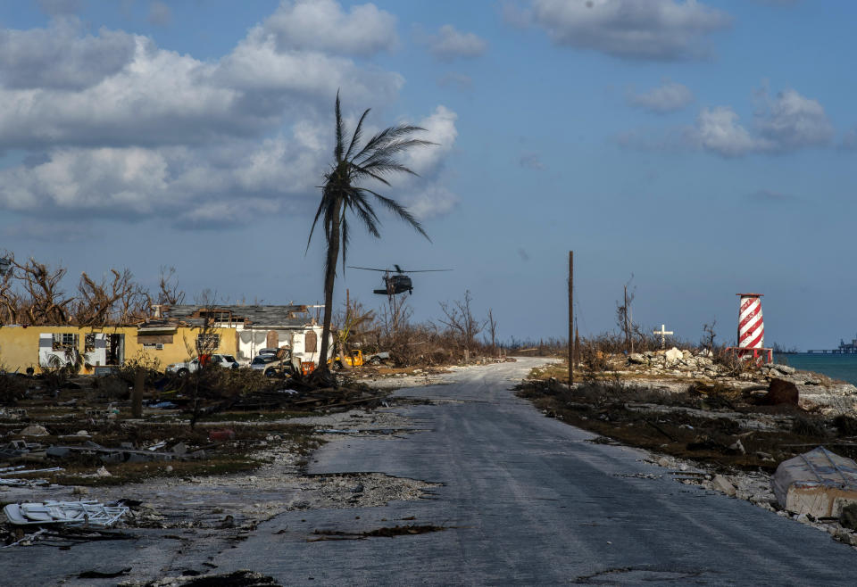 A helicopter flies over the village of High Rock after delivering emergency supplies in the aftermath of Hurricane Dorian In High Rock, Grand Bahama, Bahamas, Tuesday, September 10, 2019. (AP Photo / Ramon Espinosa)