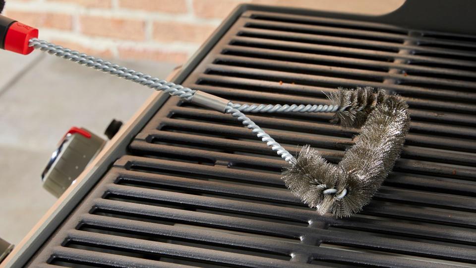 A Weber grill being cleaned