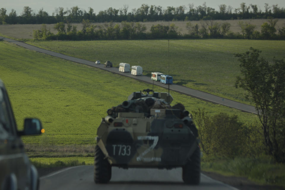 Buses with Ukrainian servicemen evacuated from the besieged Mariupol's Azovstal steel plant travel accompany Russian APC's to a prison in Olyonivka, territory under the government of the Donetsk People's Republic, eastern Ukraine, Tuesday, May 17, 2022. More than 260 fighters, some severely wounded, were pulled from a steel plant on Monday that is the last redoubt of Ukrainian fighters in the city and transported to two towns controlled by separatists, officials on both sides said. (AP Photo/Alexei Alexandrov)