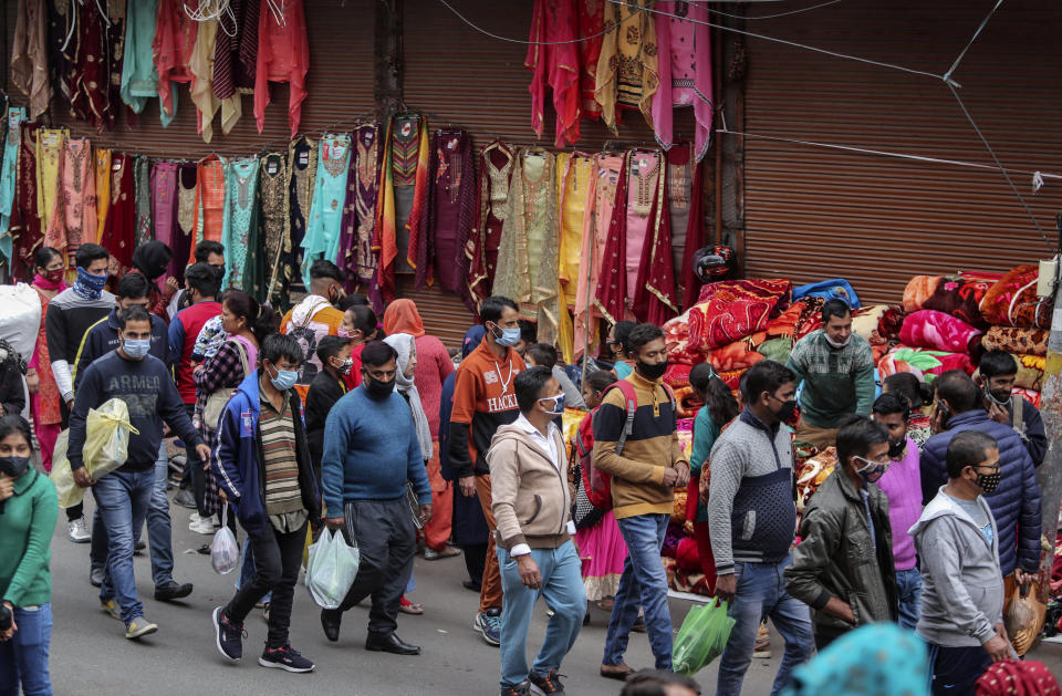 Indians, most of them, wearing face masks as a precautionary measure against the coronavirus crowd a Sunday market in Jammu, India, Sunday, Nov.22, 2020. (AP Photo/Channi Anand)