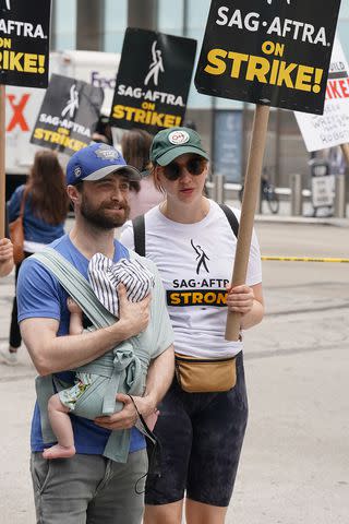 <p>Kristin Callahan/Shutterstock</p> Daniel Radcliffe and Erin Darke march with baby boy