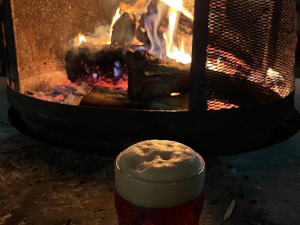 A beer in front of a fire.