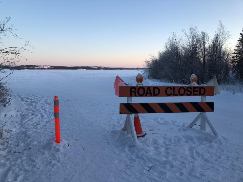 A barrier prevents cars from driving through the Yellowknife entrance to the closed Dettah ice road on Jan. 12. (Sarah Krymalowski/CBC - image credit)