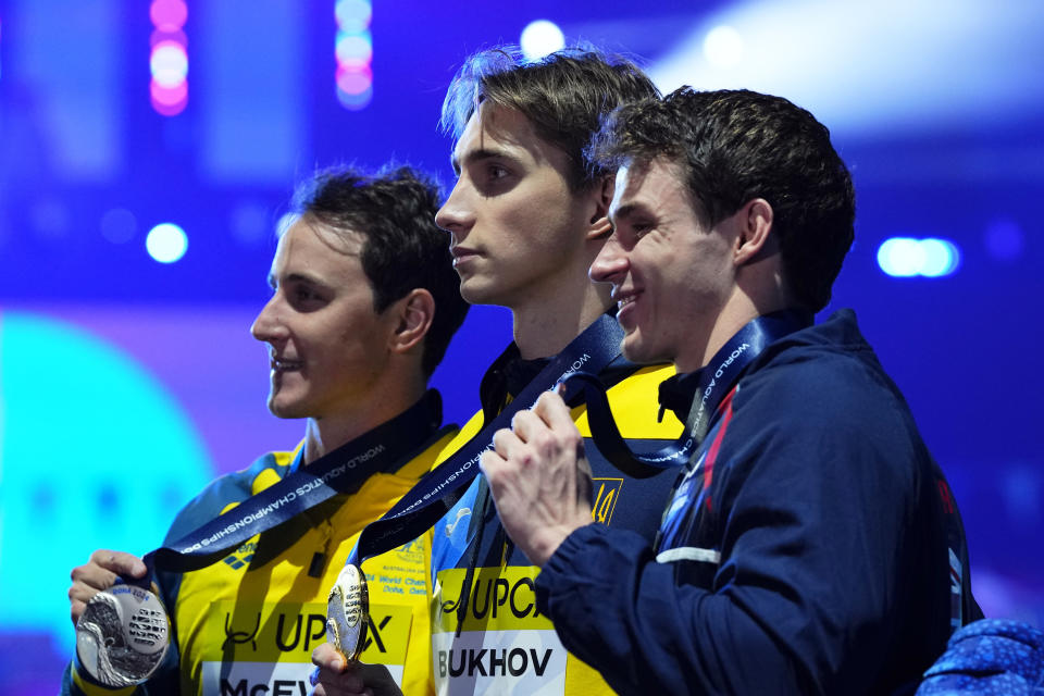 Silver medalist Cameron Mcevoy of Australia, gold medalist Vladyslav Bukhov of Ukraine and bronze medalist Benjamin Proud of Britain, from left to right, pose with their medals for the men's 50 meters freestyle final at the World Aquatics Championships in Doha, Qatar, Saturday, Feb. 17, 2024. (AP Photo/Hassan Ammar)