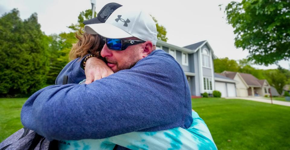 Jason Ford embraces his eighth grade son after law enforcement responded to a call at Slinger Middle School of a student having a gun May 27.