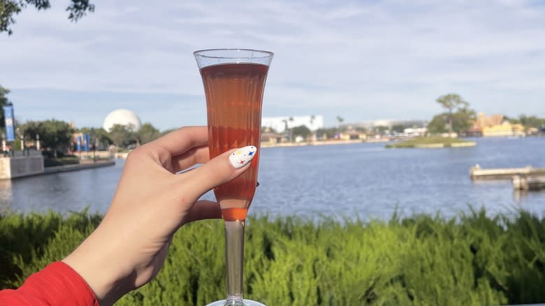 Hand holding a tall glass