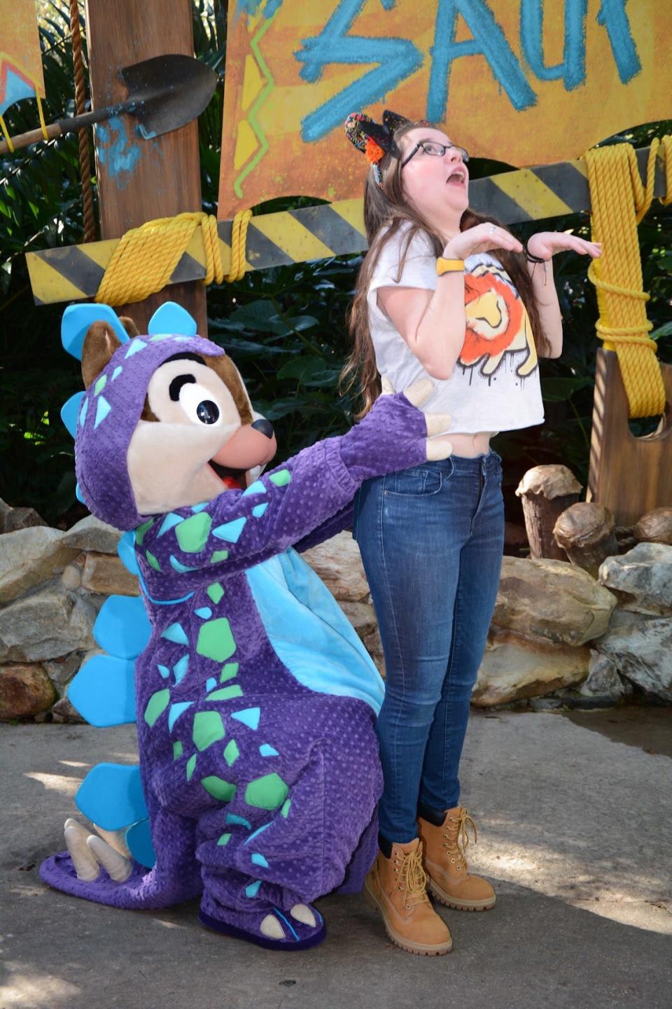 sofia posing for a funny photo with chip in his dino costume at animal kingdom