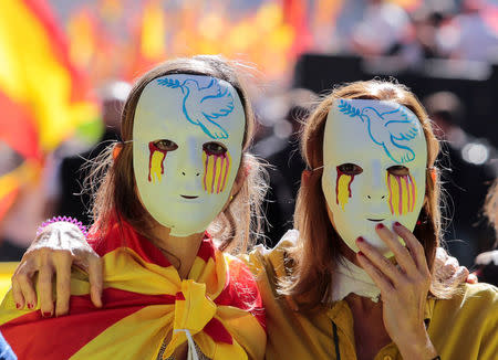 Women wear masks during a pro-union demonstration organised by the Catalan Civil Society organisation in Barcelona, Spain, October 8, 2017. REUTERS/Enrique Calvo
