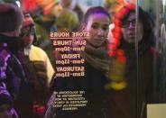 People look in the window as they line up outside a Toys"R"Us store in Times Square before their Black Friday Sale in New York November 28, 2013. REUTERS/Carlo Allegri