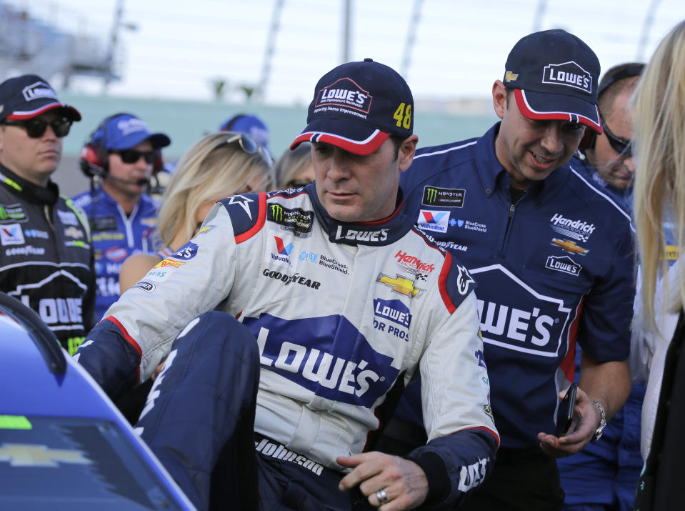 Jimmie Johnson, left, gets into his car before the NASCAR Cup Series championship auto race at Homestead-Miami Speedway, Sunday, Nov. 18, 2018, in Homestead, Fla. At right is crew chief Chad Knaus. (AP Photo/Terry Renna)