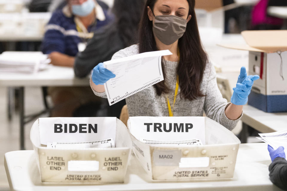 FILE - An election worker places a ballot in a counted bin during a hand recount of Presidential votes on Sunday, Nov. 15, 2020 in Marietta, Ga. (John Amis/Atlanta Journal & Constitution via AP, File)