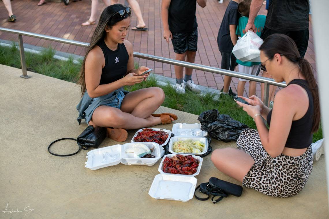 Attendees at last year’s crowded Asian Night Market found spots on the sidewalk to enjoy their food.