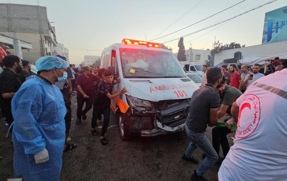 Des Palestiniens tirent une ambulance après qu'un convoi d'ambulances ait été touché, à l'entrée de l'hôpital Shifa, dans la ville de Gaza.