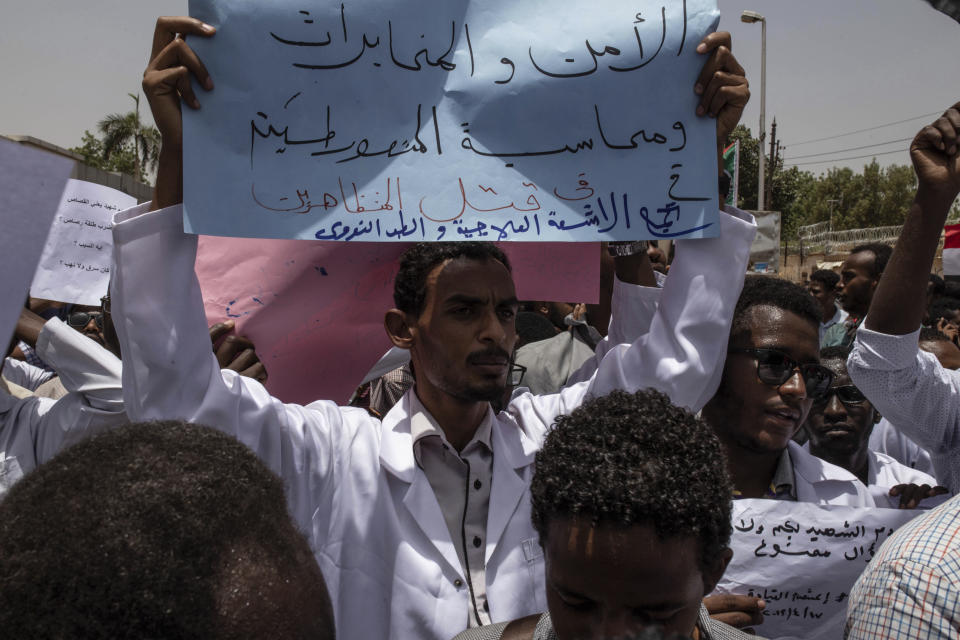 A man holds a banner calling for people who killed protesters to be punished, during a march by members of the Sudanese medical profession syndicate, at the sit-in inside the Armed Forces Square, in Khartoum, Sudan, Wednesday, April 17, 2019. A Sudanese official and a former minister said the military has transferred ousted President Omar al-Bashir to the city's Kopar Prison in Khartoum. The move came after organizers of the street protests demanded the military move al-Bashir to an official prison. (AP Photos/Salih Basheer)