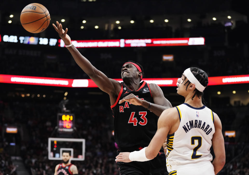 Toronto Raptors forward Pascal Siakam (43) reaches for the ball as Indiana Pacers guard Andrew Nembhard (2) looks on during the first half of an NBA basketball game in Toronto, Wednesday, March 22, 2023. (Frank Gunn/The Canadian Press via AP)