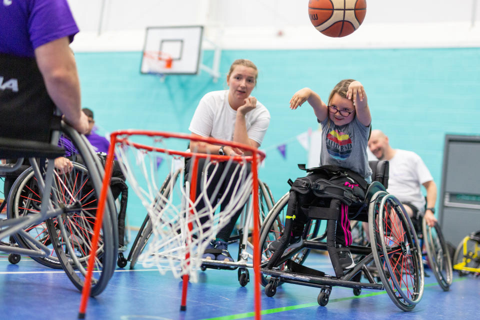 A young girl learning to play wheelchair basketball after being inspired by Robyn Love