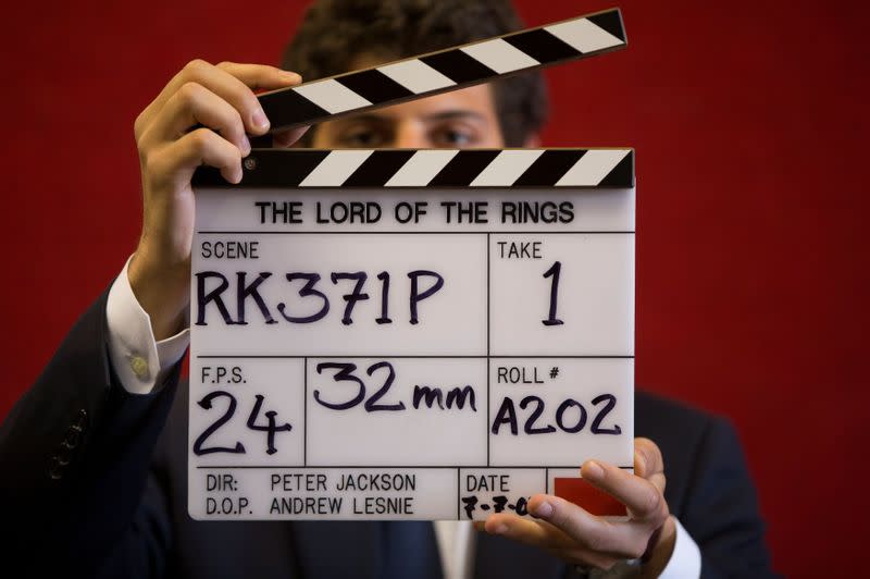 FILE PHOTO: A gallery assistant poses for a photograph with a clapper board used in the filming of the Lord of the Rings film 'Return of the King' in Bonhams auction house in London