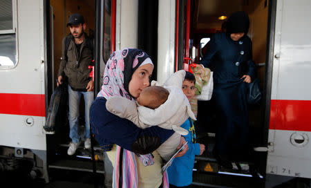 FILE PHOTO: Migrants from Syria disembark from a train on arrival from Salzburg, Austria, at Schoenefeld railway station in Berlin, Germany, October 5, 2015. REUTERS/Fabrizio Bensch/File Photo