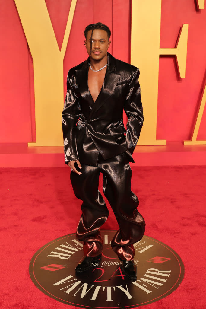 Person in a satin suit posing on the Fenty Beauty red carpet