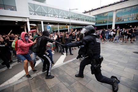 Protesters clash with police officers as they demonstrate at the airport, after a verdict in a trial over a banned independence referendum, in Barcelona