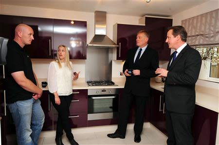 Prime Minister David Cameron (R) and Housing Minister Kris Hopkins (2nd R) speak to first time buyers Kayleigh Groom (2nd L) and her partner Chris Day during a visit to Weston Favell in Northampton, central England October 8, 2013. REUTERS/Rui Vieira/Pool