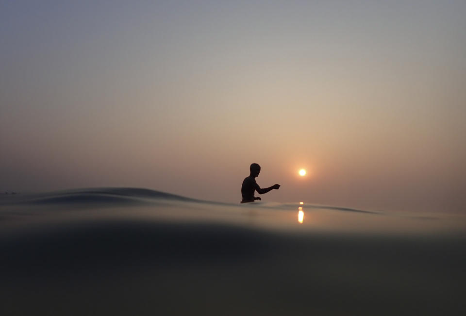 A Hindu pilgrim takes a holy dip on Makar Sankranti festival on Sagar Island, an island in the Ganges delta, in the eastern Indian state of West Bengal, Wednesday, Jan. 15, 2020. For more than 1,700 miles, stretching from the Gangotri Glacier in the Himalayas to the Bay of Bengal, the Ganges flows across the plains like a timeline of India's past, nourishing an extraordinary wealth of life. (AP Photo/Altaf Qadri)