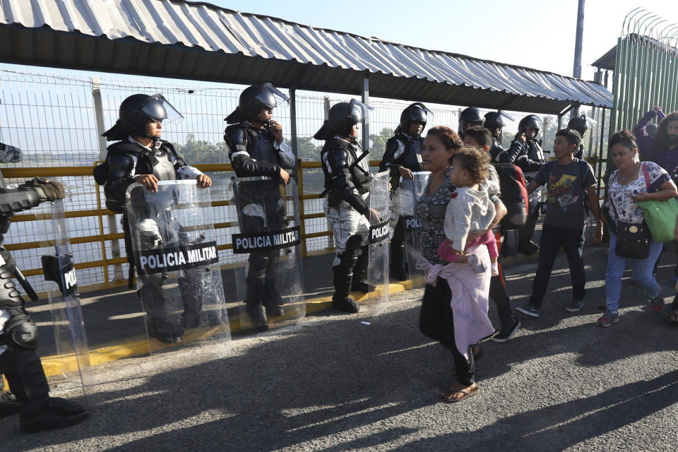 Honduran migrants cross the border into Mexico in Ciudad Hidalgo, Mexico, Saturday, Jan. 18, 2020. More than a thousand Central American migrants surged onto the bridge spanning the Suchiate River, that marks the border with Guatemala. (AP Photo/Marco Ugarte)