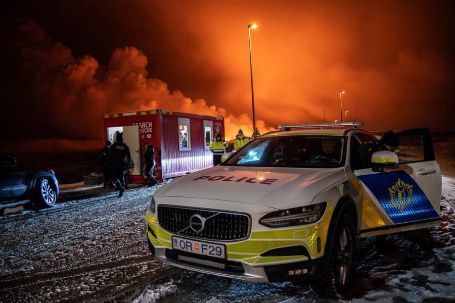 The police vehicle is parked at the entrance of the road to Grindavík with the eruption in the background, near Grindavik on Iceland’s Reykjanes Peninsula, Monday, Dec. 18, 2023. A volcanic eruption started Monday night on Iceland’s Reykjanes Peninsula, turning the sky orange and prompting the country’s civil defense to be on high alert. (AP Photo/Marco Di Marco)