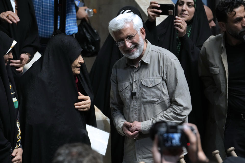 Iranian presidential candidate Saeed Jalili, right, a hard-line former nuclear negotiator, listens to a woman during a campaign stop at a sports hall in Tehran, Iran, Sunday, June 30, 2024. (AP Photo/Vahid Salemi)