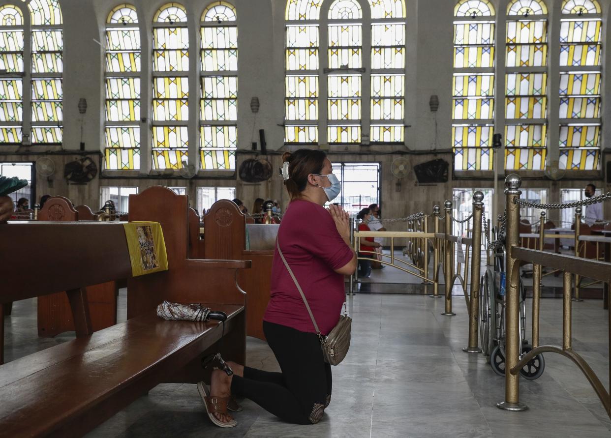 A devotee prays inside the Minor Basilica of the Black Nazarene, popularly known as Quiapo church, as it slowly reopens its doors in downtown Manila on June 5, 2020.