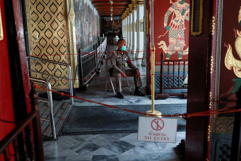 A police officer wears a protective face mask at Emerald Buddha temple, amid fear of coronavirus in Bangkok