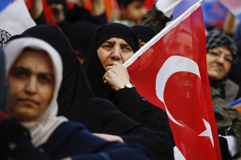 FILE-In this late Tuesday, March 19, 2019 file photo, women react as they listen to Turkey's President Recep Tayyip Erdogan addressing the supporters of his ruling Justice and Development Party, AKP, at a rally in Istanbul, ahead of local elections scheduled for March 31, 2019. As with previous elections, Erdogan has been holding multiple daily rallies across the country, using highly polarising language, portraying the opposition as traitors who are supported by terrorists, blaming ills on foreign forces and stirring up nationalist and religious sentiments. (AP Photo/Emrah Gurel, File)