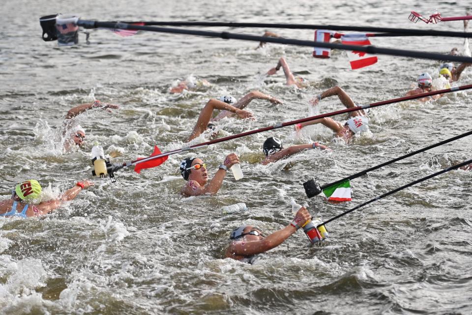 <p>TOPSHOT - Italy's Rachele Bruni (C) takes refreshment at a feed station along the course during the women's 10km marathon swimming event during the Tokyo 2020 Olympic Games at the Odaiba Marine Park in Tokyo on August 4, 2021. (Photo by Oli SCARFF / AFP) (Photo by OLI SCARFF/AFP via Getty Images)</p> 