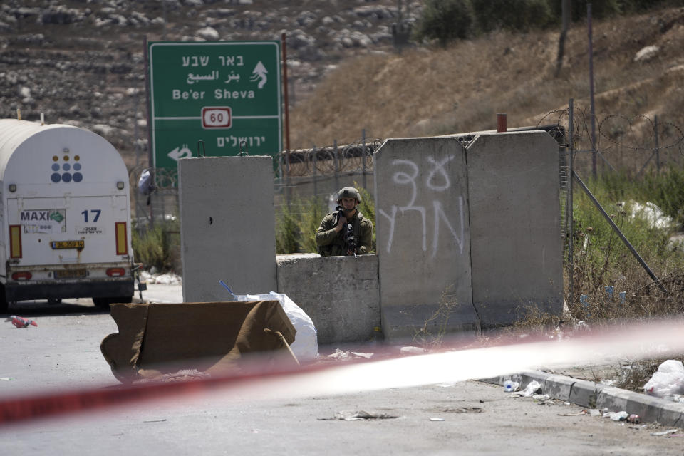 An Israeli soldier works at the site of an alleged car-ramming attack near Beit Hagai, a Jewish settlement in the hills south of the large Palestinian city of Hebron, Wednesday, Aug. 30, 2023. The Israeli military said security forces shot the Palestinian driver as he accelerated toward a military post. A soldier struck by the car was evacuated to a nearby hospital for treatment. There was no immediate word on the condition of the suspected Palestinian assailant. (AP Photo/Mahmoud Illean)