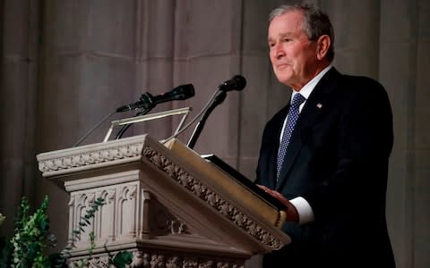 Former President George W Bush pauses as speaks  - Credit: AFP