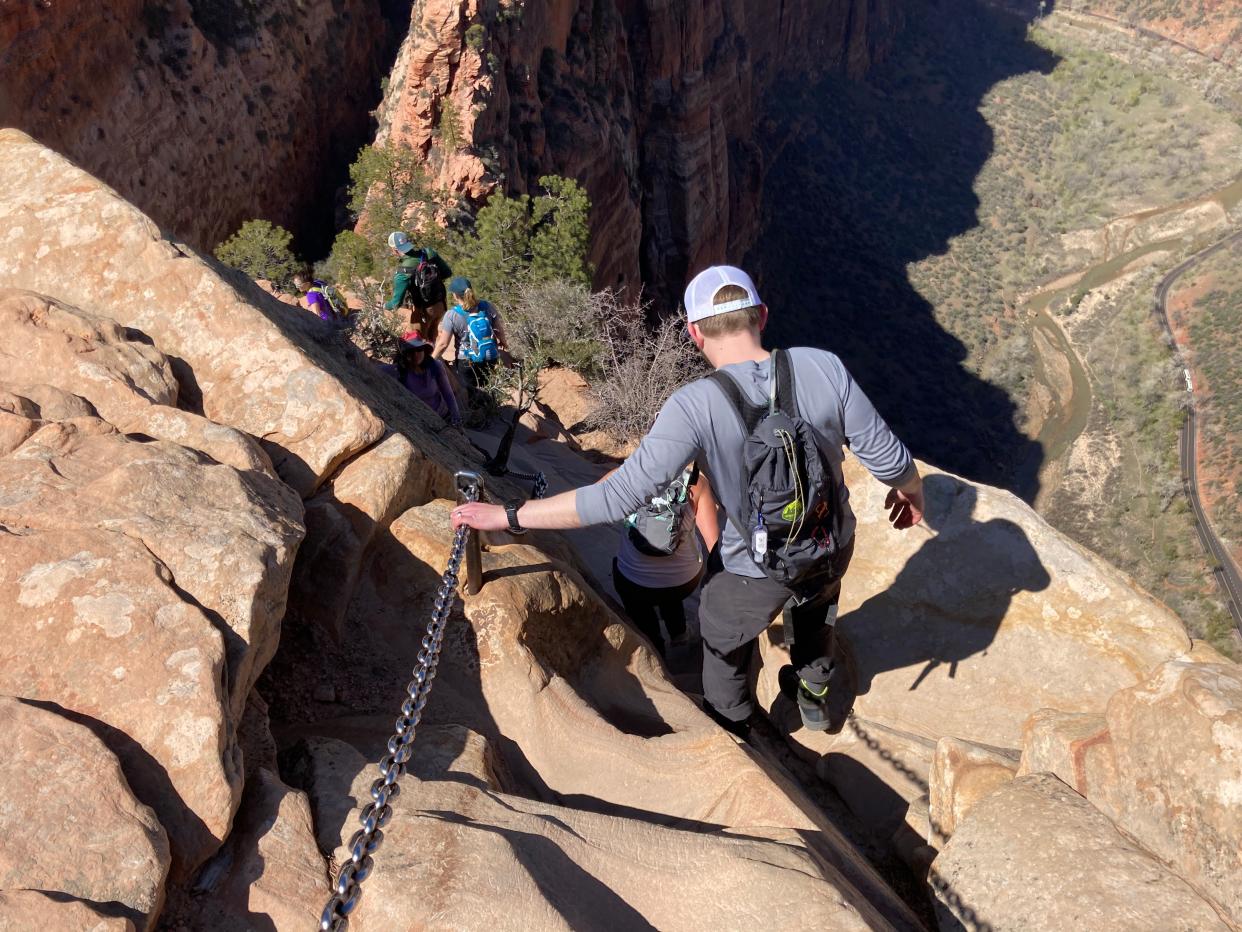 A group of friends navigates the chain section of the Angels Landing hike in Zion National Park on Friday, April 1, 2022.