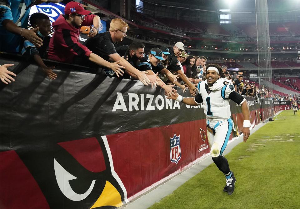 Nov 14, 2021; Glendale, Arizona, USA; Carolina Panthers quarterback Cam Newton (1) high-fives the fans after the Panthers defeated the Arizona Cardinals at State Farm Stadium.