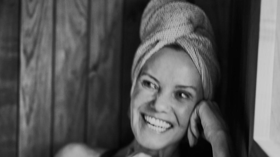 Woman smiling with a towel around her head