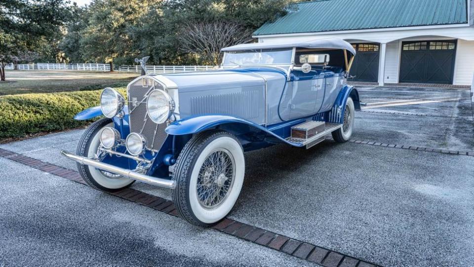 A blue and white car parked in a driveway

Description automatically generated