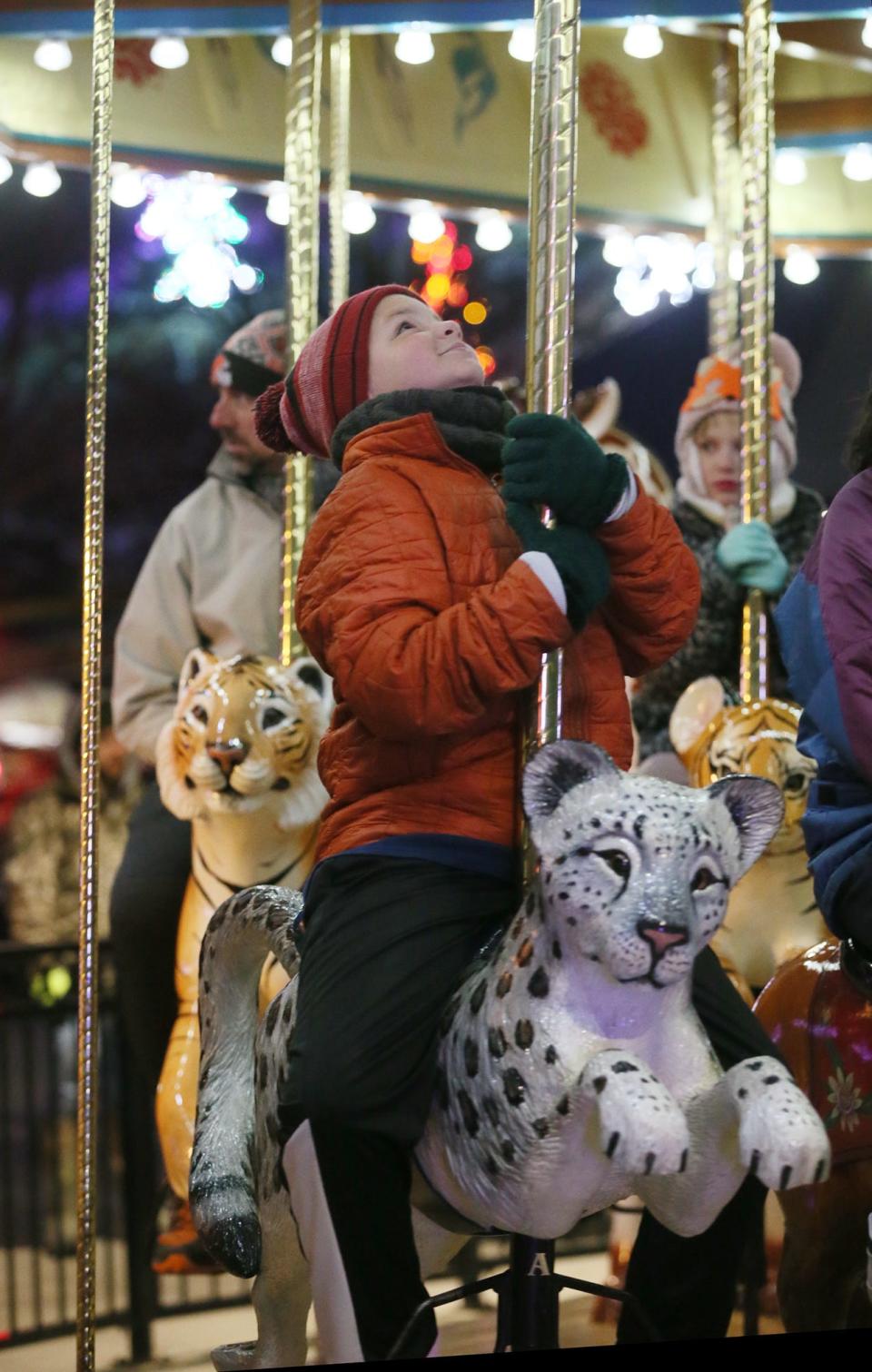 Andrew Steck, 10 of Canton rides a snow leopard on the carousel during the Wishes Can Happen family event at the Akron Zoo on Saturday.