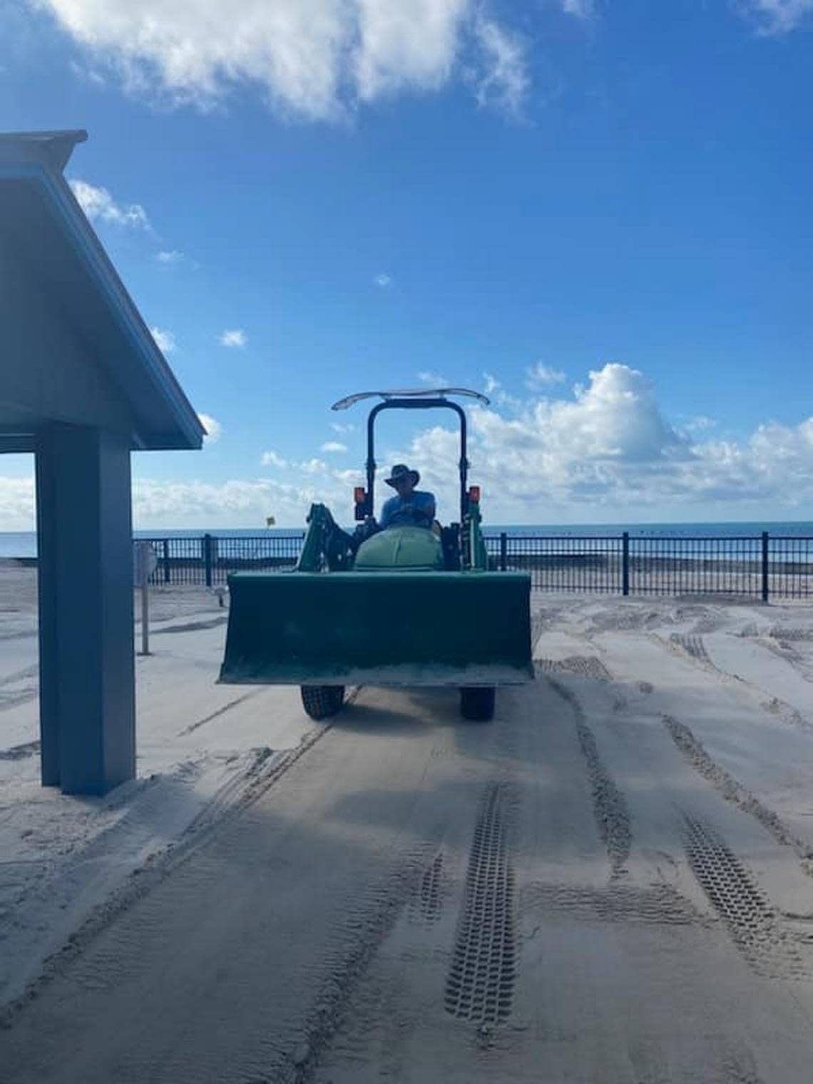 A worker drives a front-end loader at Clarence H. Higgs Memorial Beach Thursday, Oct. 6, 2022, cleaning up debris left behind by Hurricane Ian.