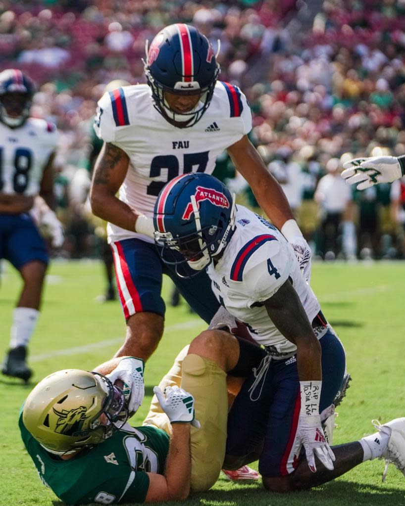 FAU defensive back Jarron Morris, who forced a fumble, tackles a USF receiver during Saturday's win in Tampa.