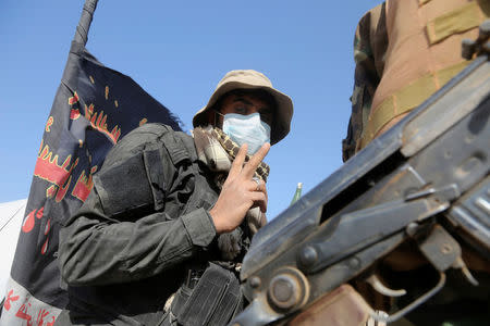 A member of Popular Mobilization Forces (PMF) fighter gestures during an operation against Islamic State militants in west of Mosul, Iraq November 14, 2016. REUTERS/Stringer