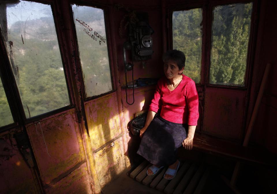 A conductor sits inside a 60-year-old cable car in the town of Chiatura