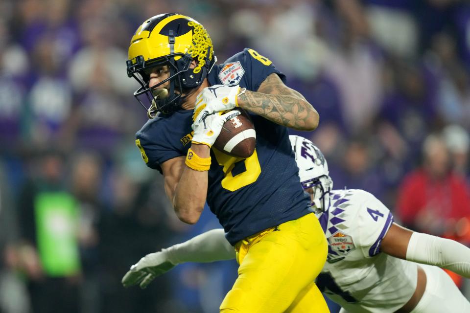 Michigan wide receiver Ronnie Bell (8) makes a catch in front of TCU safety Namdi Obiazor (4) in the 2022 Fiesta Bowl at State Farm Stadium in Glendale, Arizona.